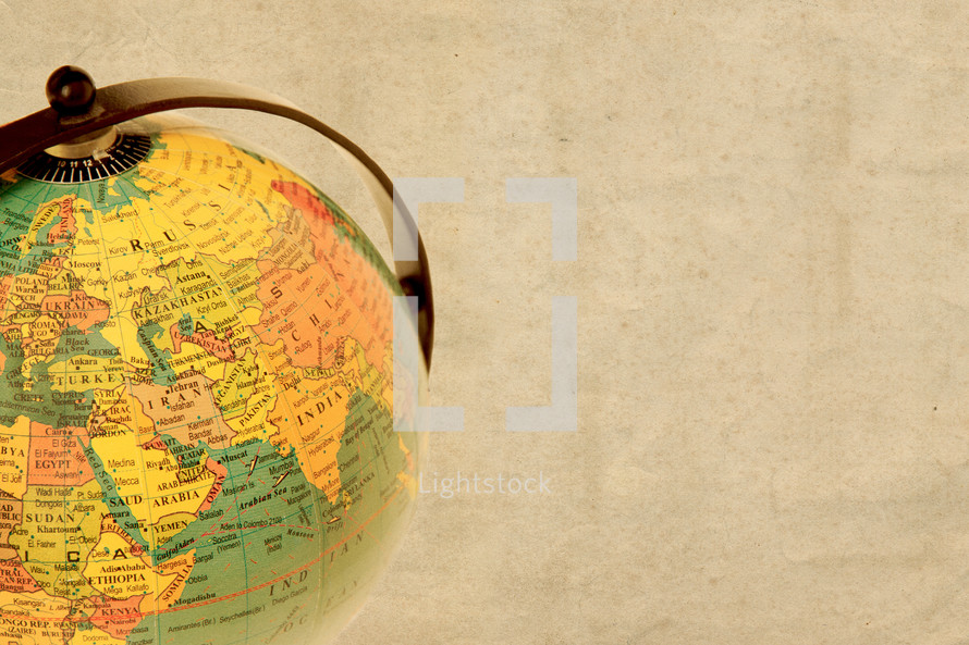 World globe against a beige paper background showing the middle east