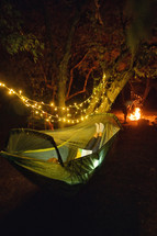a person reading in a hammock at night 