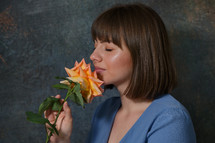 Woman Holding And Smelling A Rose Flower