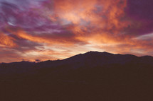 fiery pink and purple clouds over the mountains at sunset