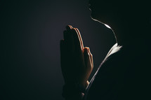 Person with hands folded in prayer