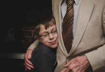 child hugging his grandfather 