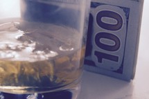 Scotch glass and one hundred dollar bill 