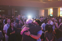 men hugging at a worship service 
