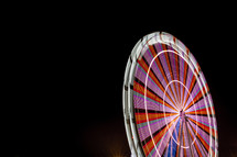Ferris wheel illuminated at night with long exposure and isolated on black sky