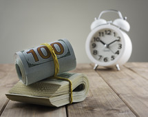 alarm clock and a roll of money