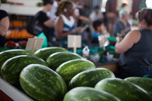 watermelon and people shopping at a farmers market 