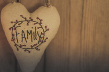 A heart shaped pillow with the word Family on it