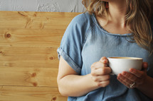 a woman with a coffee cup sitting in a both 