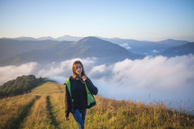 a teen girl walking up a mountainside 