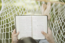 woman reading a Bible in a hammock
