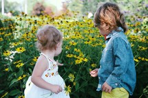 toddlers in a field of daisies 