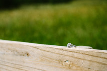 engagement ring on wood railing 