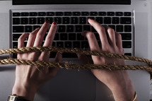 hands tied to a computer keyboard.