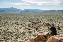 a man looking out at a desert landscape 
