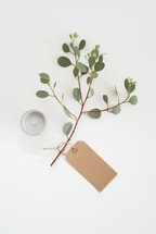 eucalyptus twig, votive candle, and gift tag 