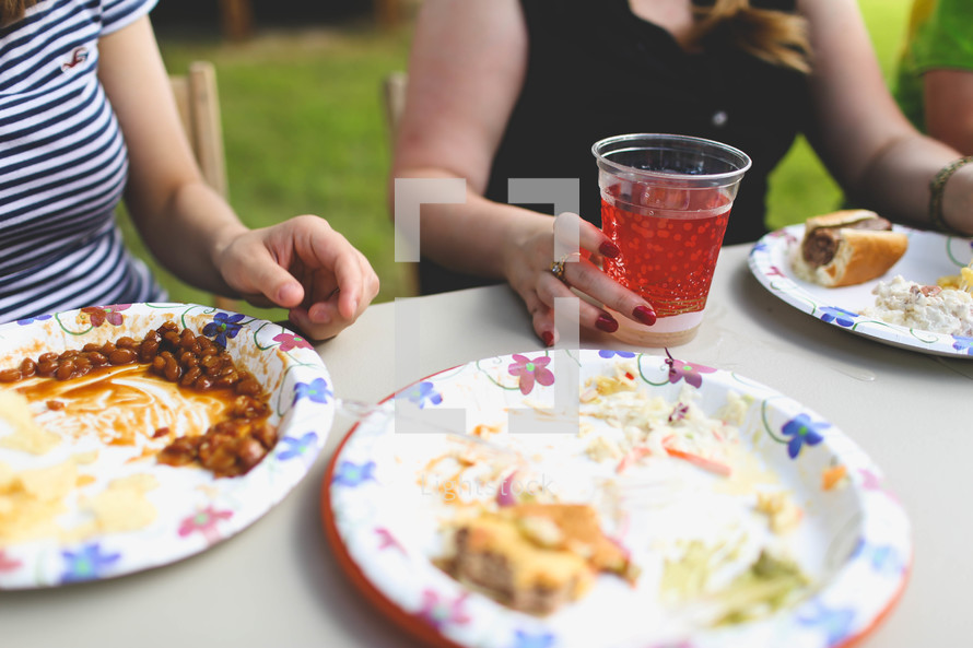 paper plates and plastic cups at a picnic outdoors 