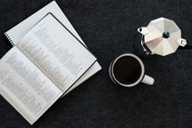 coffee mug, journal, Bible, creamer, and coffee on a desk 
