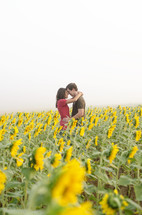 couple hugging in a field of sunflowers