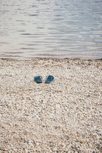 flip flops on a beach near water 