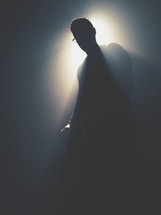 silhouette of a man standing in light 