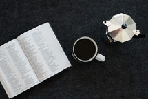 creamer, coffee mug, and Bible on a table 