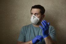 man putting on gloves and mask 