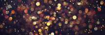 Golden shiny glitter, sparkles, light bokeh on dark background. New year, Christmas background. Banner with copy space. Festive backdrop for greeting card