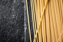 A pile of spaghetti dry on the table. Against a dark background. High quality photo