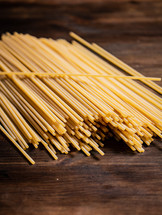 A pile of spaghetti dry on the table. Against a dark background. High quality photo