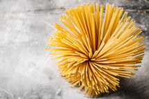 A pile of spaghetti dry on the table. Against a dark background. High quality photo