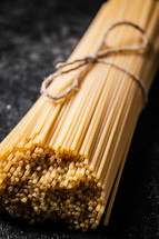 A pile of spaghetti dry on the table. Against a dark background. High quality photo