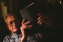 elderly man reading a Bible 