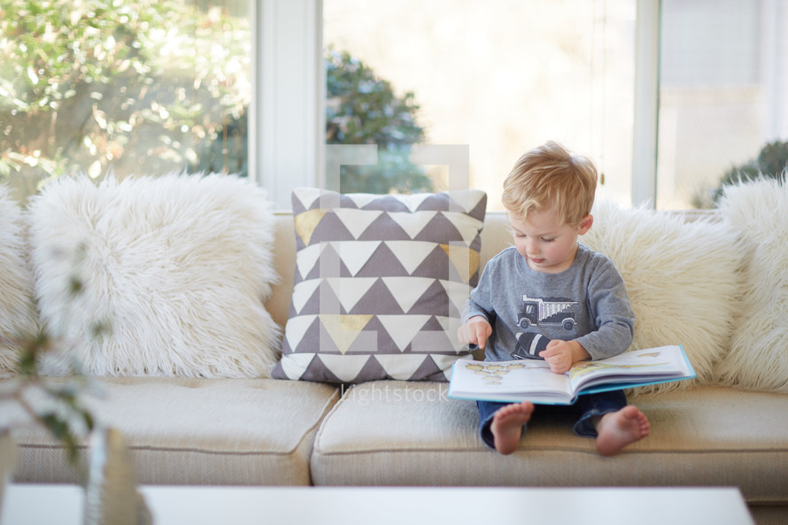 a toddler boy reading a book 