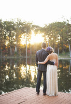 bride and groom standing on a dock 