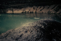 falling rain on rocks near a lake 