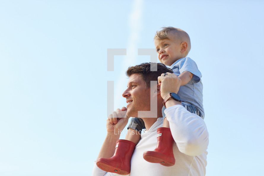 a toddler boy on father's shoulders