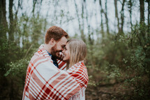couple wrapped up in a plaid blanket 