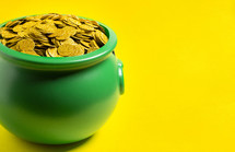 Pot Full of Golden Coins Isolated on a yellow Background