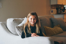 smiling girl sitting on a couch 