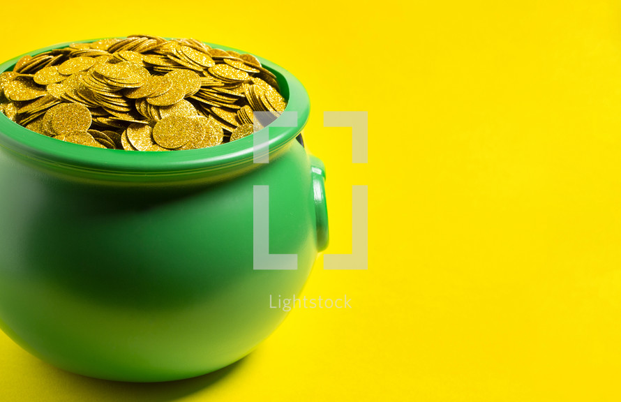 Pot Full of Golden Coins Isolated on a yellow Background