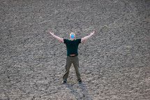 Man raises his hands and praying for rain in dry land