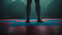 Legs of male boxer with skipping rope