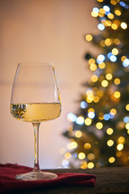 Wine glass next to a Christmas tree