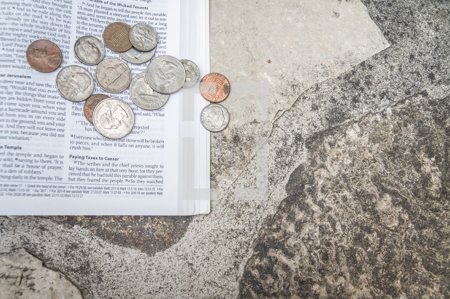 Money on an open Bible with a rock background