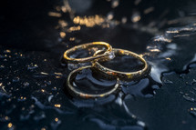 wedding bands on a wet surface 