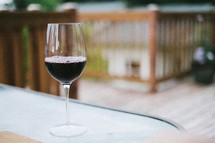 glass of red wine on a glass outdoor table 