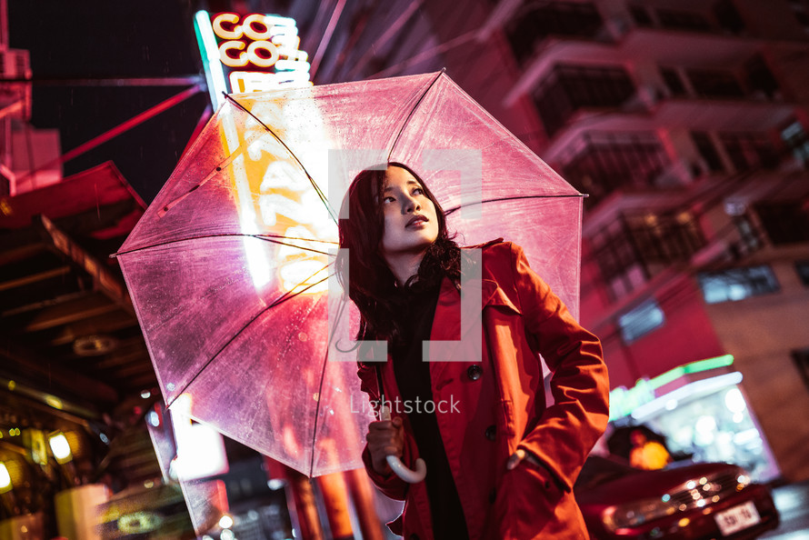 woman standing with an umbrella at night 