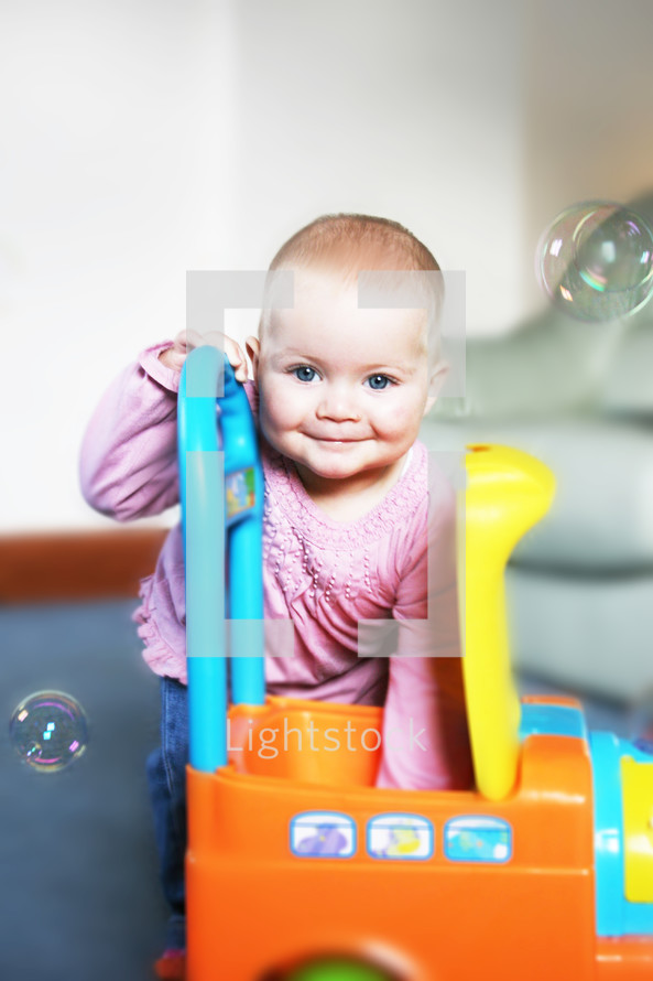 toddler girl playing with toys and bubbles 