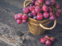 Rose grapes in wooden bucket on a woden table